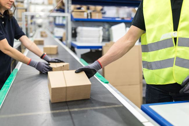 Workers sorting packages in a fulfillment center