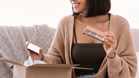 woman opening box she receive via cosmetic fulfillment