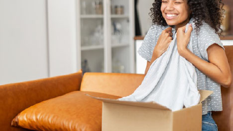 woman opening box she received from an apparel fulfillment company